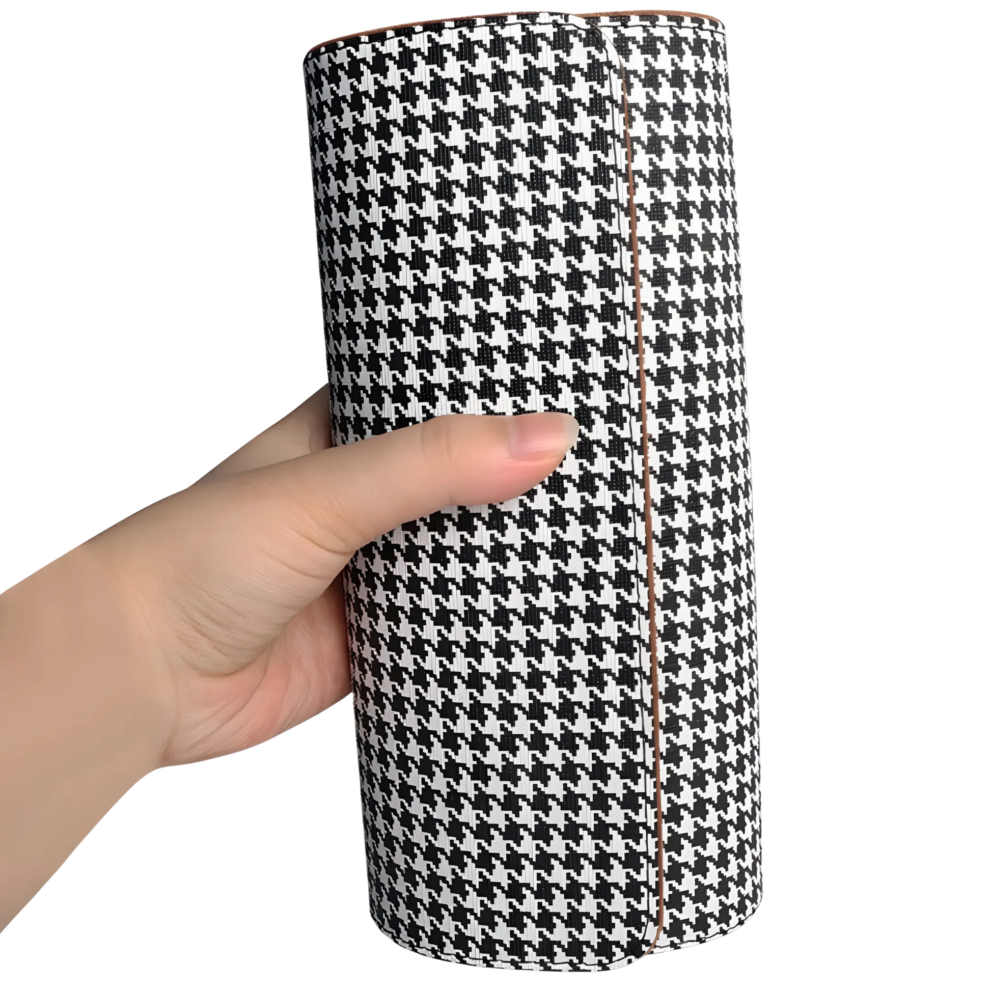 Luxury watch roll organiser for multiple watches. Hand holding a cylindrical black and white houndstooth patterned product against a white background