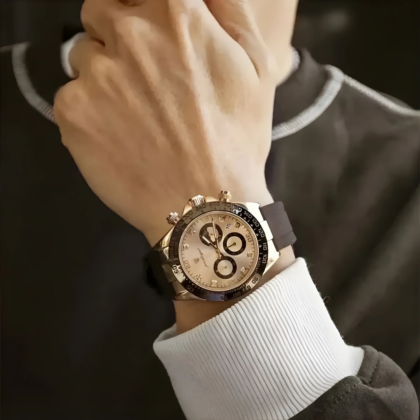 Close-up of a person wearing a luxury watch with a dark strap and gold case.
