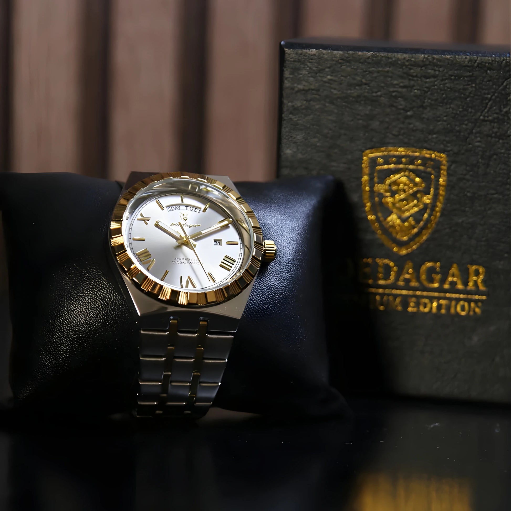 Gold and silver watch on a black cushion with a branded box in the background