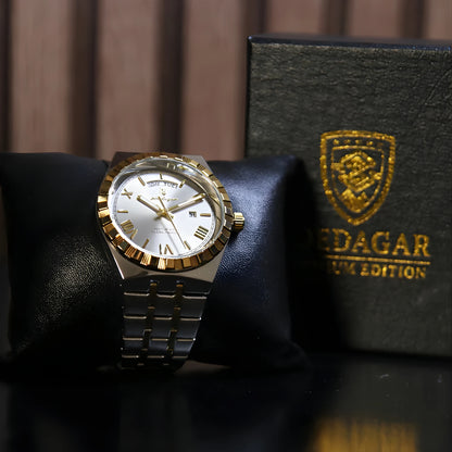 Gold and silver watch on a black cushion with a branded box in the background