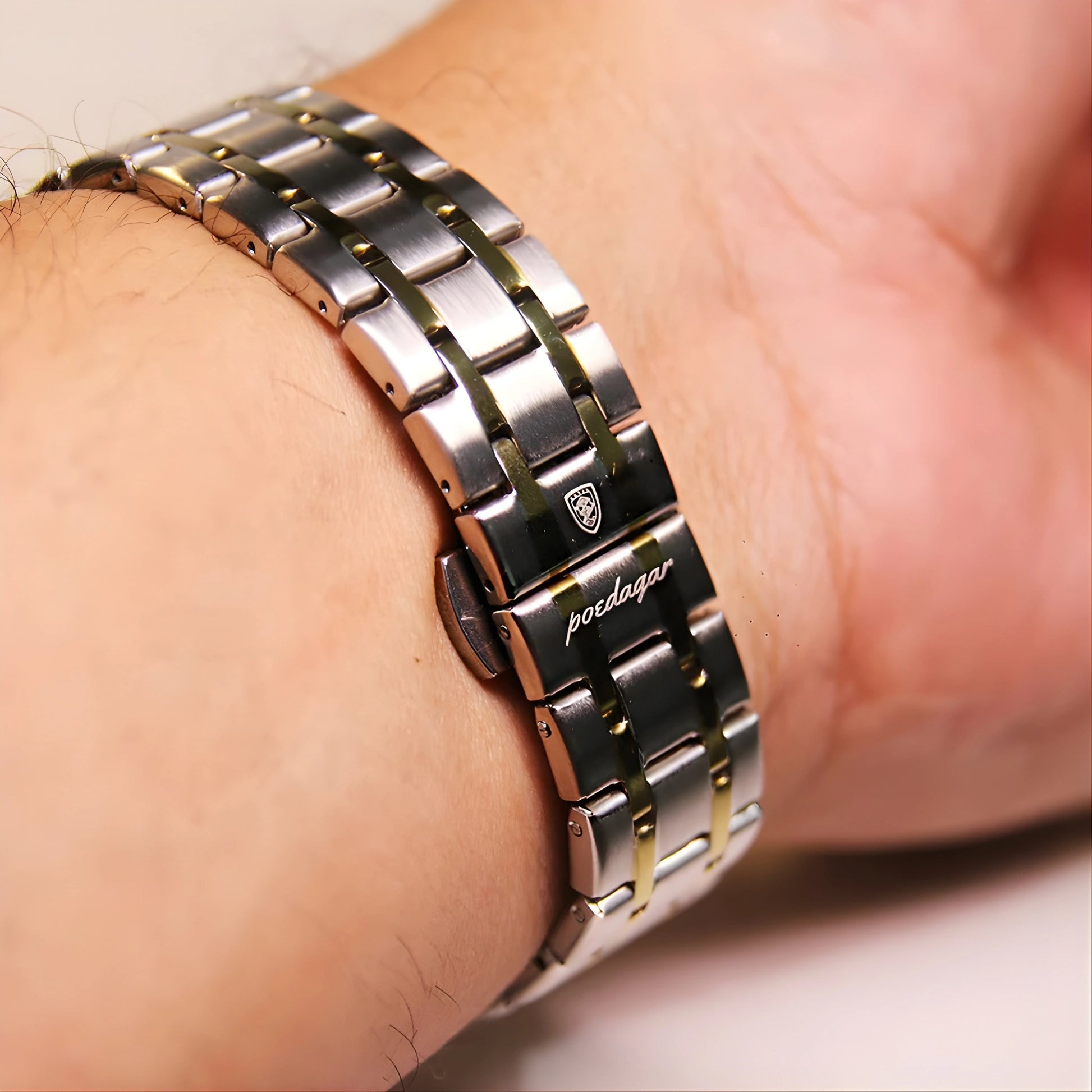 Close-up of a person wearing a two-tone metal watch on a plain background