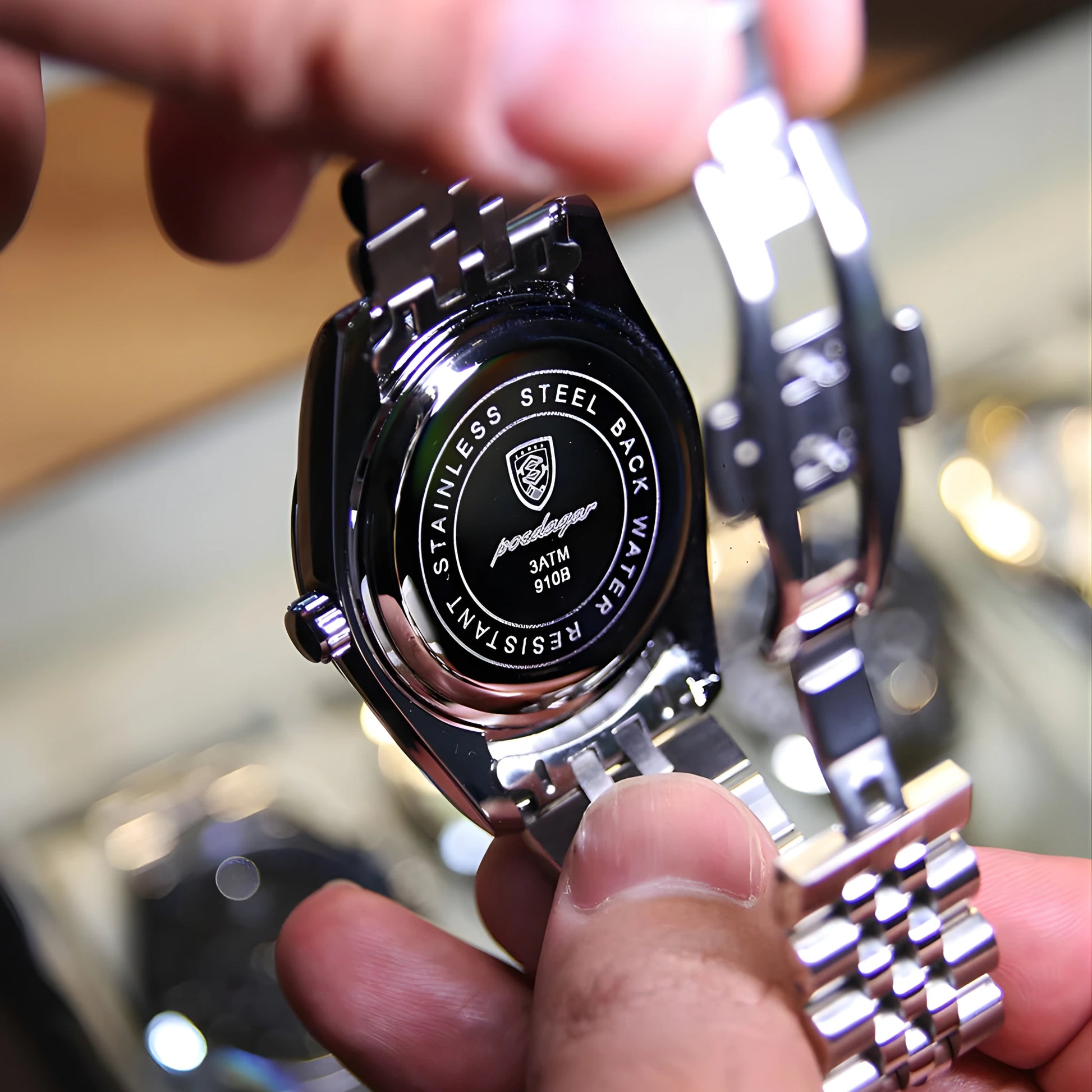 Close-up of a person holding a luxury watch with visible brand logo.