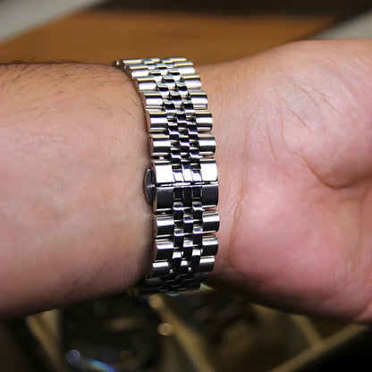 Close-up of a person's wrist wearing a silver metal watch.