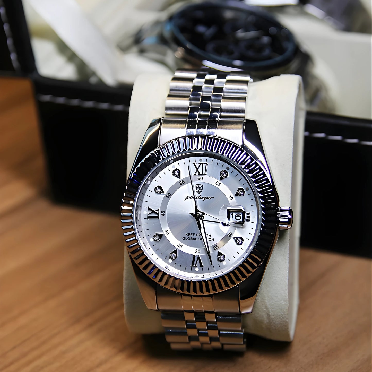 Silver wristwatch with a detailed face on a wooden surface