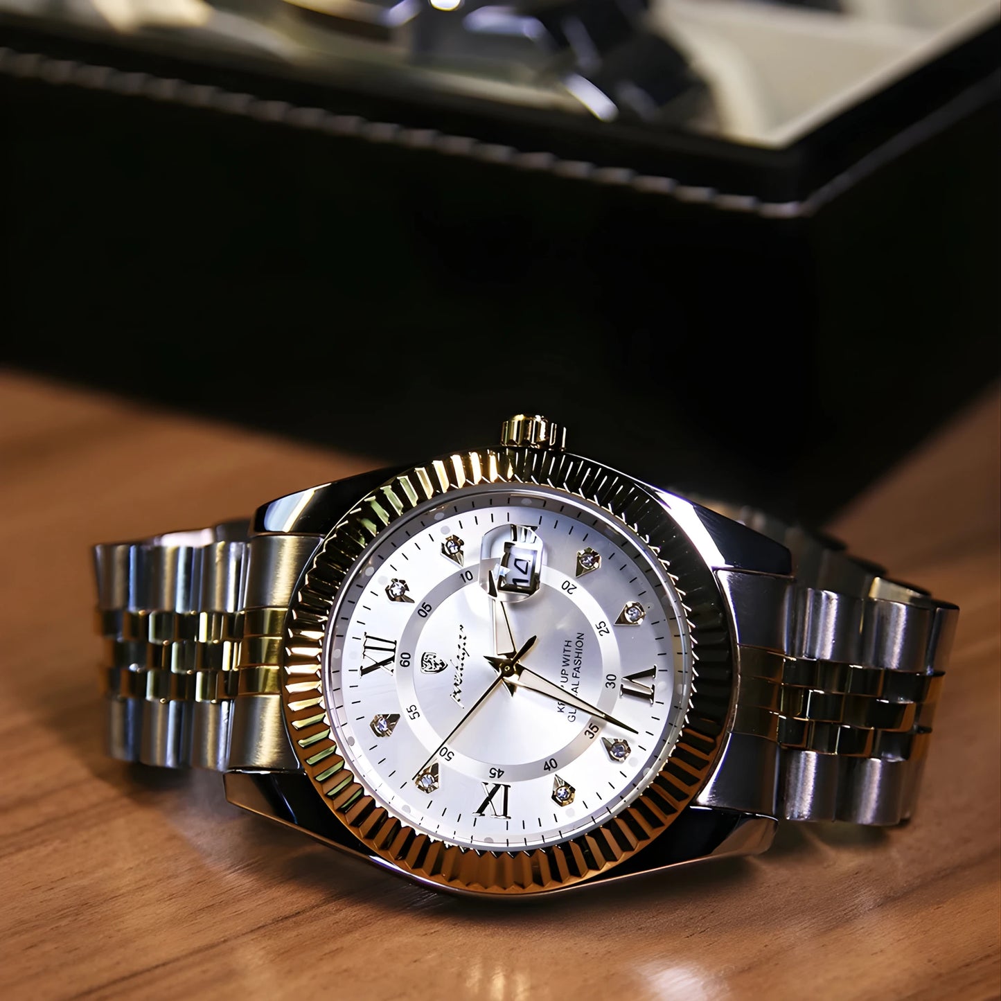 Silver and gold watch with a detailed face on a wooden surface