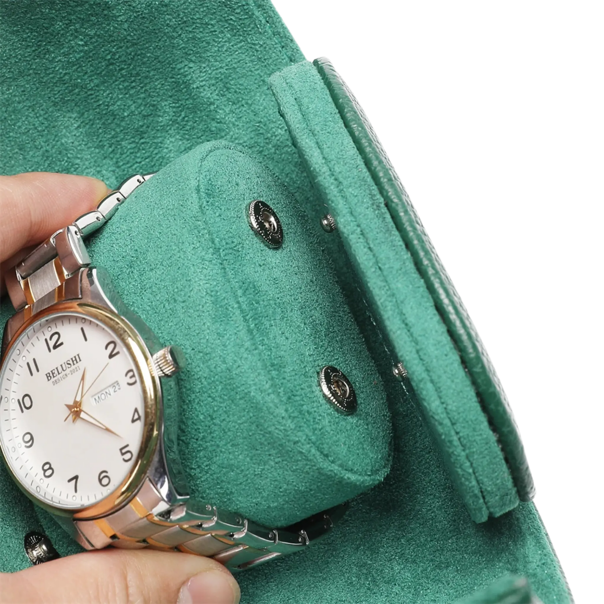 Hand holding a silver watch against a green coat background
